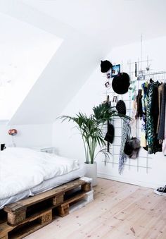 a bed sitting under a window next to a wooden pallet