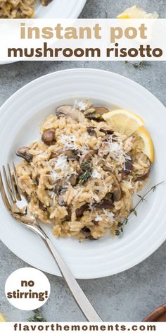 a white plate topped with pasta covered in mushrooms and parmesan cheese next to lemon wedges