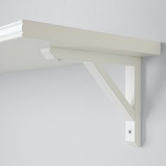 a close up of a white shelf on a wall