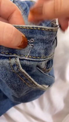 someone is holding their pocket open to show the inside of his jeans