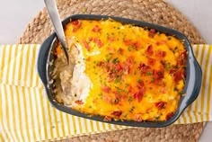 a casserole dish with meat and vegetables in it on a yellow and white place mat