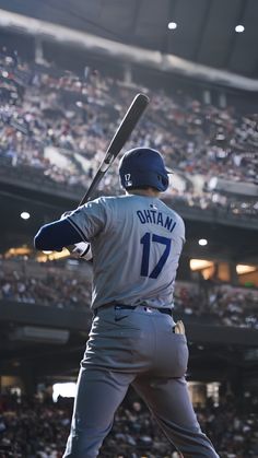 a baseball player holding a bat on top of a field in front of a crowd