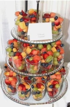 a triple layer tray filled with lots of different types of fruit on top of each other