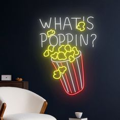 a neon sign that says, what's poppin? in front of a chair