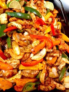 a tray filled with chicken and vegetables on top of a table