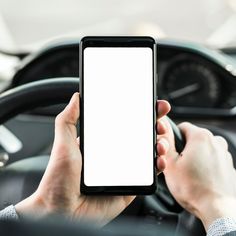 a person holding a phone in their hand while driving