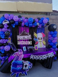 a table topped with balloons and decorations for a fortnite masqueradee party