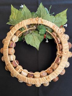 a close up of a wreath made out of shells and leaves on a black background