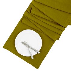 a white plate with silverware on top of it next to napkins and forks