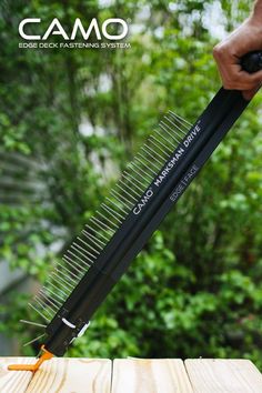 a person is holding a comb over a piece of wood