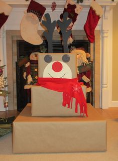 a cardboard box with reindeer head and scarf on it in front of a christmas tree