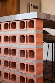 a stack of bricks sitting on top of a wooden floor next to a table and chairs