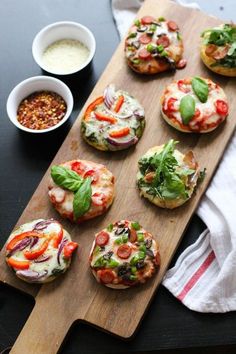 mini pizzas with different toppings on a cutting board