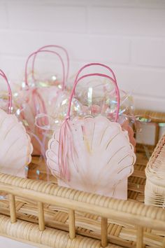 pink seashells are sitting on a wicker basket next to some candy canes