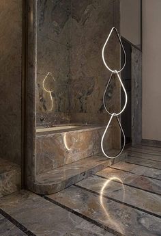 an artistic light sculpture in the middle of a tiled floor next to a bathtub