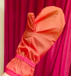 an orange umbrella is stuck in the corner of a room with pink drapes on it