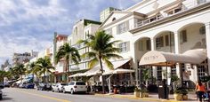 a street lined with tall white buildings and palm trees