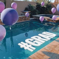 balloons are floating in the air next to a swimming pool with an adora sign on it