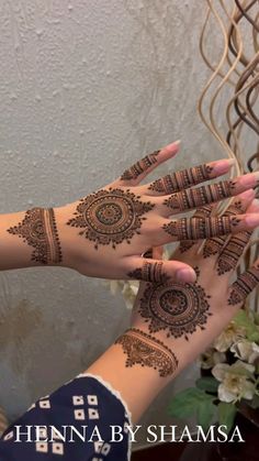 two hands with henna designs on them