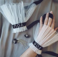 two hands with black and white accessories on them