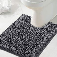 a bathroom rug that is on the floor next to a toilet