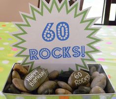 a birthday card in a box with rocks on the table and a sign that says 60 rocks