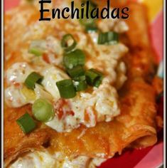 a red plate topped with cheesy enchiladas covered in cheese and green onions