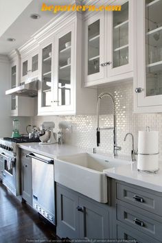 a kitchen with white cabinets and stainless steel appliances