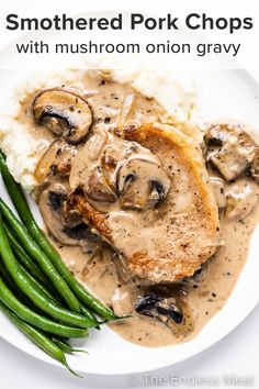 a white plate topped with meat covered in mushroom gravy next to green beans