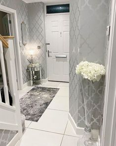 a vase with white flowers in it sitting on the floor next to a door way