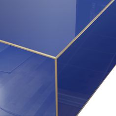 a blue glass table with gold trim around the edge