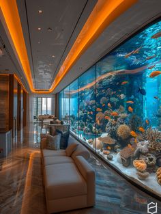 a living room filled with lots of furniture next to a large fish tank covered in corals