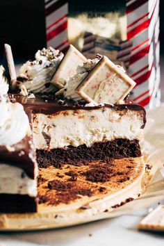 a piece of chocolate cake with white frosting and candy bars on top, sitting on a plate