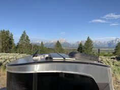 the back end of a vehicle with mountains in the background