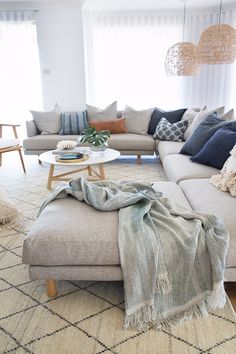 a living room filled with lots of furniture and pillows on top of the couches