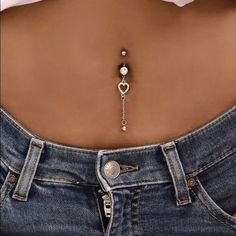 the back of a woman's jeans with a chain attached to her waist and an earring in the shape of a heart