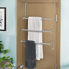 a towel rack with two towels hanging on it's sides in front of a blue wall