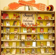 there is a book shelf with many books on it and a sign that reads feast of delicious books