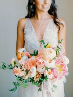 a woman holding a bouquet of flowers in her hands