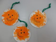 three paper plates with pumpkin faces on them