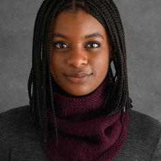 a woman with dreadlocks wearing a scarf