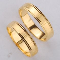 two yellow gold wedding rings sitting on top of each other