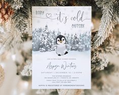 a baby it's cold outside party with a penguin on the front and snow covered trees in the back