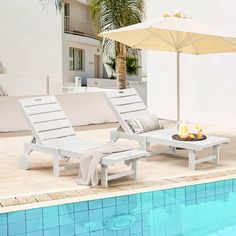 two lounge chairs next to a swimming pool with an umbrella over the fire pit on it