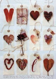 a bunch of hearts hanging from strings on a wall with other items attached to them