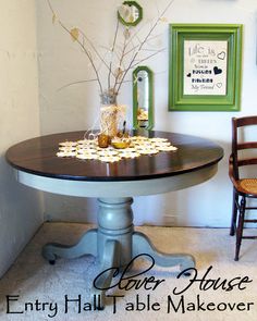 a dining room table with flowers on it and two chairs in front of the table