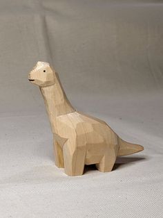 a wooden toy dinosaur on a white background