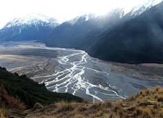 a river running through a valley surrounded by mountains