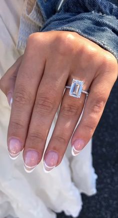 a woman's hand with a ring on it and a diamond in the middle