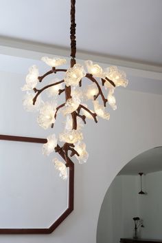 a chandelier with lights hanging from it's branches in a living room